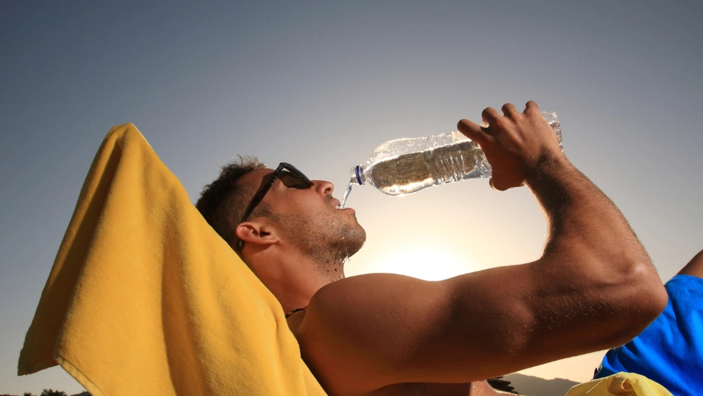 Ragazzo che beve durante una giornata d'estate