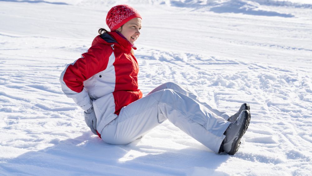 Ragazza seduta sulla neve - Come prepararsi a praticare gli sport invernali 